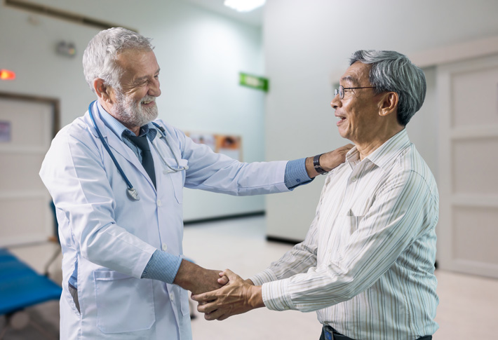 Doctor greeting patient in hospital hallway